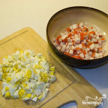 Отварить и нарезать яйца. Измельчить мясо краба или крабовые палочки.