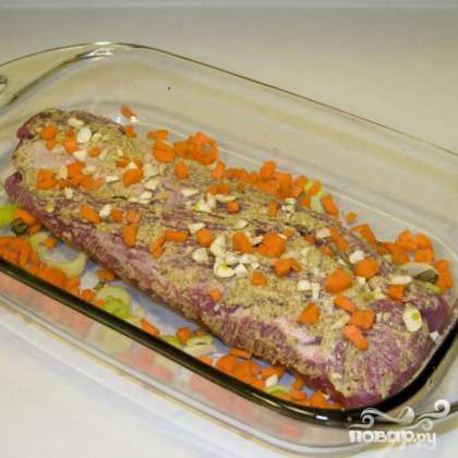 Поместить вырезку в термостойкую форму для выпечки. Полить горчицей, посыпать рубленым чесноком, морковью и остатками сельдерея.