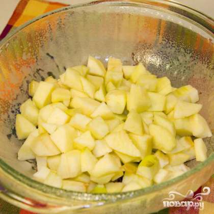 Очистить яблоки от кожуры и нарезать кубиками. Выложить в термостойкую посуду.