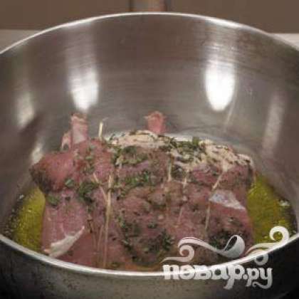 Залить оливковое масло в глубокую сковороду. Тушить мясо на медленном огне. Влить немного белого вина.