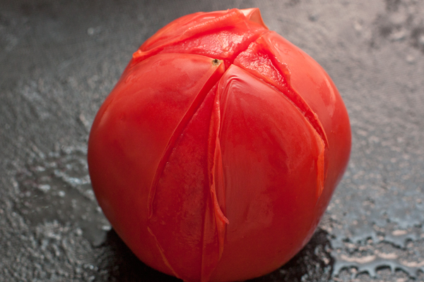 На помидоре сделайте снизу неглубокий крестообразный надрез, опустите на полминуты в кипяток, затем снимите кожицу.