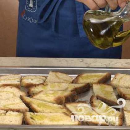 Выложить ломтики хлеба на противень, щедро полить оливковым маслом и запечь в духовке около 3-5 минут.
