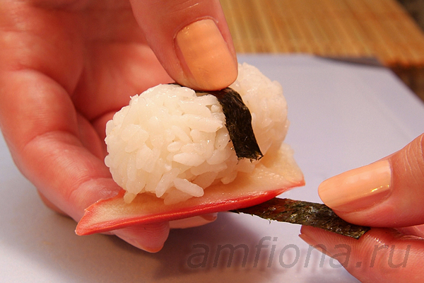 Нигири-суши с хоккигаем оборачивают тонкой полоской из нори, чтобы моллюск лучше держался на рисе. Прижмите один кончик "ленточки" к рису и достаточно плотно оберните ее вокруг моллюска и риса.