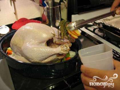 Набить полость индейки ароматической смесью. Положить птицу поверх овощей. Запекать в духовке 30 минут на максимуме.