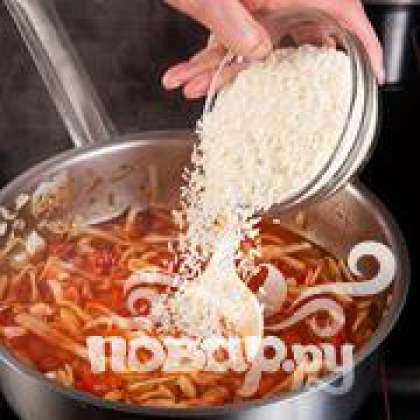 Засыпать рис, добавить нарезанные помидоры и фасоль. Довести до кипения, приправить солью и перцем, перемешать и варить на медленном огне около 30 минут.