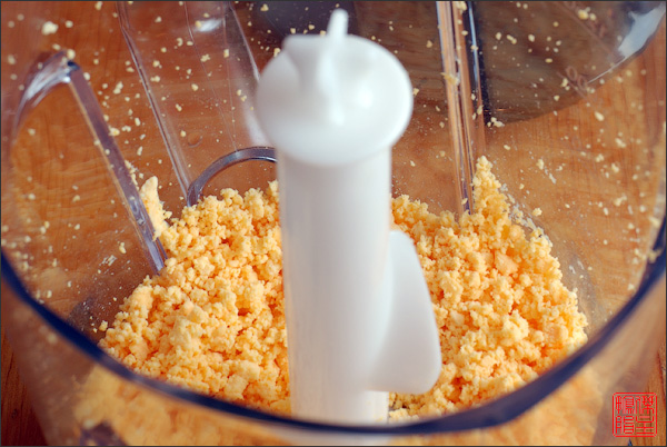 В желтки от сваренных яиц добавить сахар и хорошо перемолоть в блендере, пока масса не станет однородной. После этого желтки можно дополнительно протереть через сито.