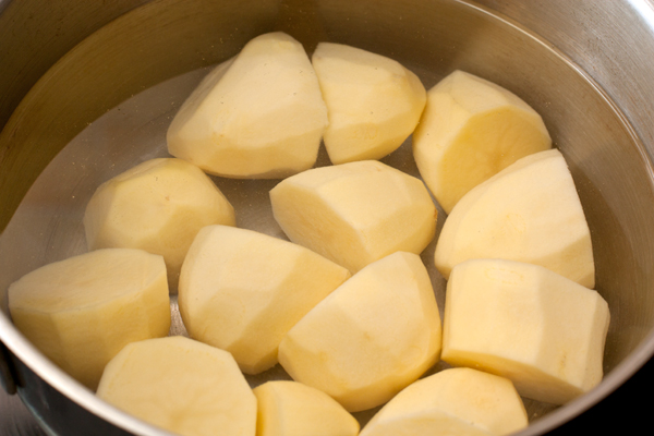 Картофель очистите и сварите в подсоленной воде. Некрупную свеклу, не очищая, сварите в отдельной кастрюле или запеките в духовке при 200 градусах, завернув в фольгу. 