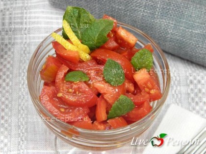 Поливаем заправкой помидоры, добавляем листики мяты и перемешиваем.  Томатный салат с мятой и лимоном готов!