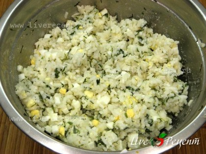 Для следующего слоя нашего курника рис смешиваем с рублеными яйцами, зеленью и маслом. Солим и перчим по вкусу.