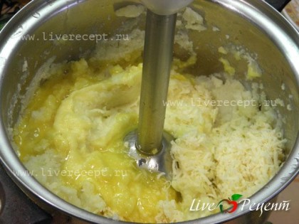 Сливаем с готового картофеля воду, добавляем яичные желтки, масло и мелко натертый сыр. Все тщательно взбиваем при помощи блендера.