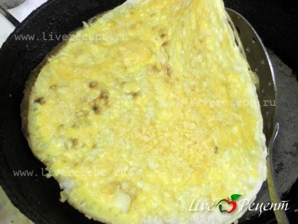 Когда яйцо немного схватится, добавляем натертый сыр. Еще немного прожариваем и складываем лаваш пополам. В идеале ека складывается треугольником, но легче сложить пополам или конвертиком.