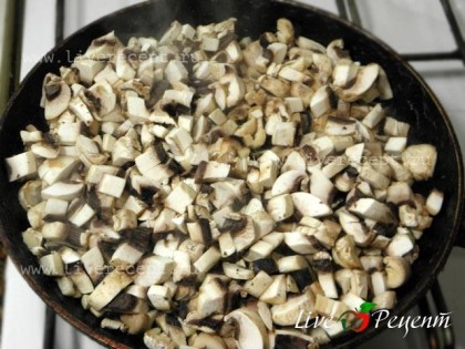 Для приготовления крабового салата с грибами, нарезаем мелко грибы и поджариваем их на растительном масле.