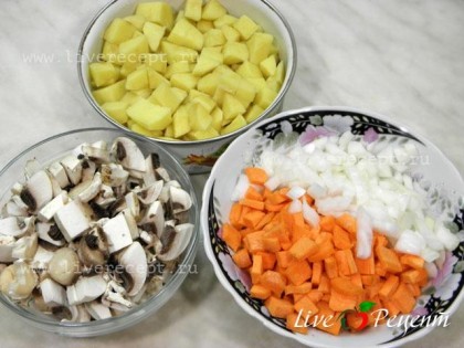 Чтобы приготовить куриный суп с зеленым горошком и грибами, нарезаем небольшими кубиками картофель, грибы, морковь и лук. Чеснок мелко рубим.Морковь, по желанию, можно натереть на терке.