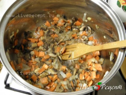 В кастрюлю кладем сливочное и растительное масло, кладем морковь, лук, чеснок и грибы. Жарим, помешивая, до слегка золотистого цвета.