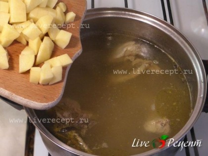 Картофель нарезаем кубиками и добавляем в кастрюлю через полчаса после начала варки курицы.