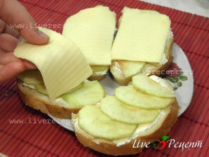 Затем выкладываем сыр, порезанный на тонкие кусочки, он должен полностью покрыть яблоки. Гренки запекаем в духовке (180 градусов), сыр должен расплавиться.