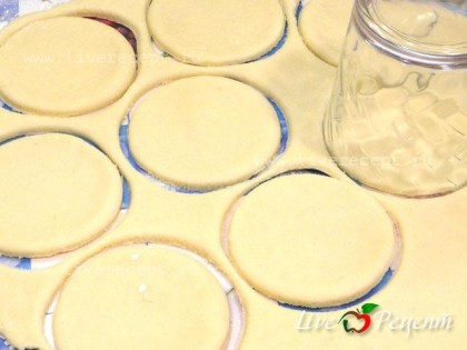 Раскатываем тесто в пласт толщиной примерно 3-4 мм и при помощи стакана вырезаем кружочки.