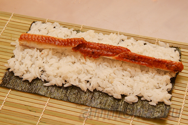 Нарежьте жареного угря unagi kabayaki тонкими ломтиками и положите их по центру. На один ролл потребуется около 20 граммов рыбы. 