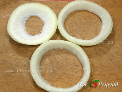 Чтобы приготовить яйца, жаренные в луковых кольцах, режем лук кольцами шириной 1,5 см.