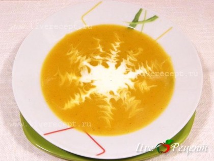 Суп-пюре из тыквы наливаем в тарелку и добавляем 2 ст. лож. сливок. С помощью зубочистки можно сделать красивый узор и подаем на стол.
