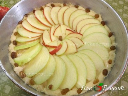 Тесто выкладываем в смазанную растительным маслом форму. Сверху по кругу кладем дольки яблок. Украшаем изюмом и выпекаем 30-35 минут в духовке при 180-200 градусах. Яблочный пирог с изюмом готов!
