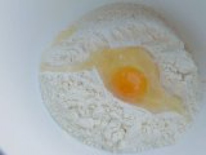 1 К муке добавить яйцо. В глубокую миску просеять муку, сделать посередине углубление, добавить соль, вбить яйцо.