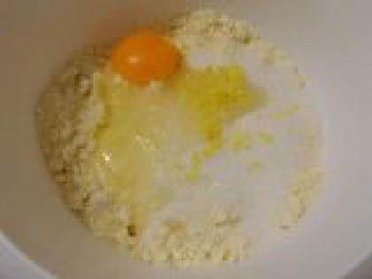2 Добавить сахар, яйцо и цедру. Затем всыпать сахар, вбить яйцо и добавить цедру лимона (если любите достаточно ощутимый лимонный вкус - добавьте цедры больше).