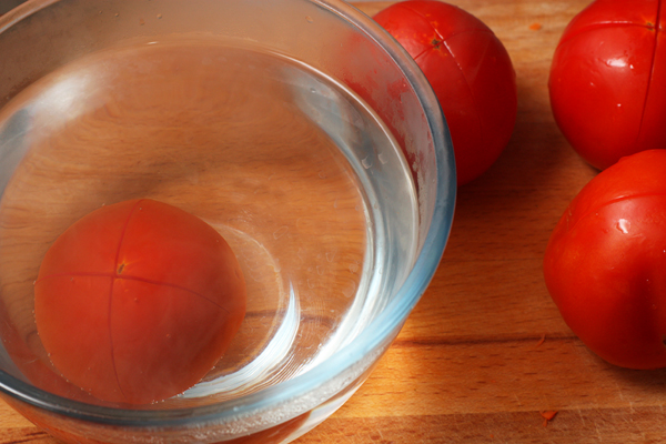 Для более нежной консистенции кабачковой икры помидоры лучше очистить от кожицы. Для этого внизу помидора сделайте крестообразный надрез и опустите в кипяток на полминуты.