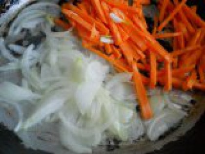 3 Лук и морковь порезать. Лук и морковь очистить. Нарезать лук тонкими полукольцами, морковь - длинной соломкой (можно использовать терку для корейской моркови). Выложить на разогретую с растительным маслом сковороду (масла много не нужно, суп не должен быть жирным, образовавшегося от варки курицы жира будет вполне достаточно).