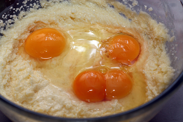 Размягченное масло взбейте с сахаром до светлой пышной массы. Для самой нежной консистенции теста можно использовать сахарную пудру. Затем добавьте яйца.