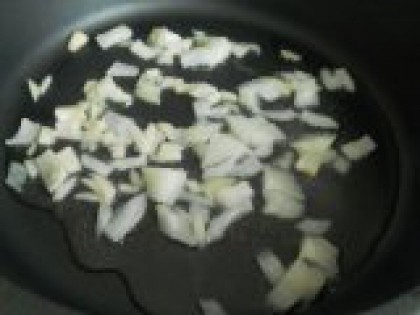 3 Обжарить лук и чеснок. Сковороду разогреть с растительным маслом. Лук очистить и порезать небольшими кусочками, чеснок измельчить. Выложить лук и чеснок в сковороду и обжарить 2-3 минуты на среднем огне.