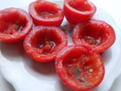 1 Разрезать помидоры, убрать мякоть. Подготовить помидоры: помыть, срезать немного верхушку и разрезать каждый помидор пополам - горизонтально. Ложечкой убрать мякоть, формируя чашечки. Каждую помидорную чашечку внутри посолить и посыпать черным молотым перцем (можно и красным - для остроты).
