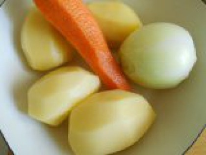 2 Очистить овощи. Воду налить в кастрюлю и поставить на огонь. Картофель, репчатый лук и морковь очистить и помыть.