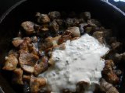 5 Добавить сметану. В сковороду к мясу добавить обжаренные грибы и подготовленную сметанную смесь. Все хорошенько размешать. Поставить на огонь.