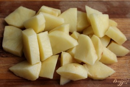 Картофель режем на кусочки и отправляем в кастрюлю.