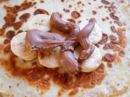 Я вместо шоколада использую шоколадно- ореховую пасту "Нутелла". Выкладываем ее поверх бананов.