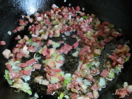 Пожарить колбасу с белой частью зеленого лука.