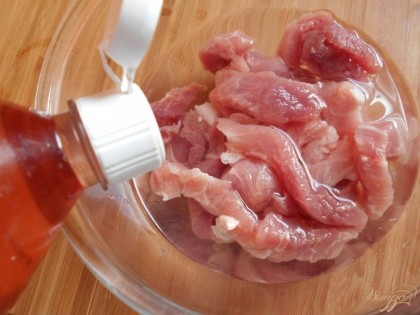  Мясо очищаем от пленок и нарезаем продольными полосками. Заливаем его винным уксусом.