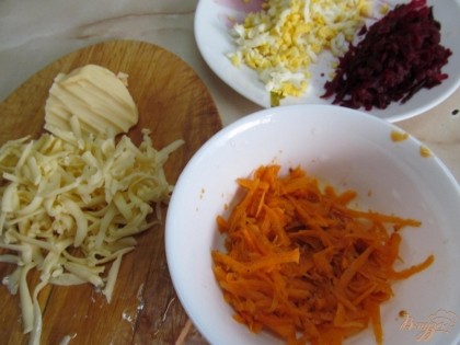 Свеклу, морковь и сыр натереть на крупной терке. Яйца мелко нарезать.