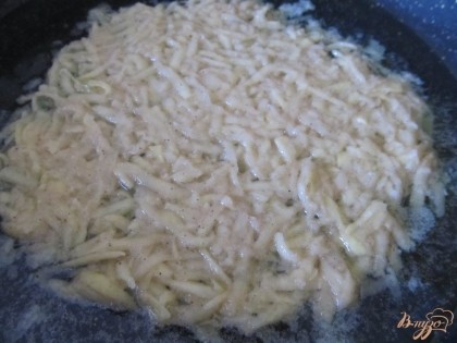 На сковороде разогреваем растительное масло (слой масла не больше 5-7 мм) и выкладываем картофель. Разравниваем его ложкой, делая тонкий слой.