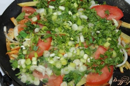Когда картофель достаточно обжарена добавить помидоры и зелень, накрыть крышкой на пару минут.