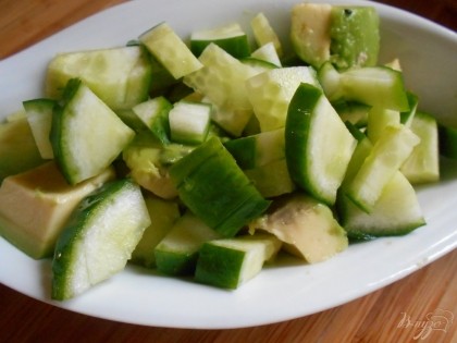 Выкладываем огурцы к авокадо и добавляем листья салата.