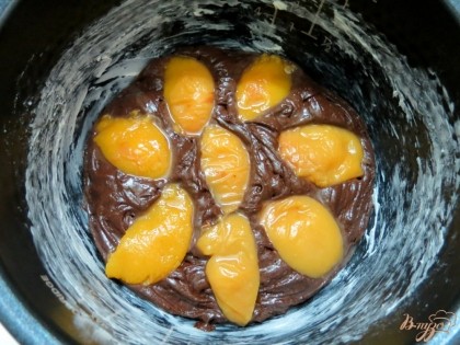 В тесто втискиваем половину персиков.