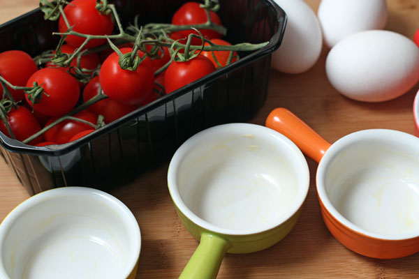 Вымойте помидоры и яйца, формочки для запекания смажьте маслом. духовку разогрейте до 200 градусов.
