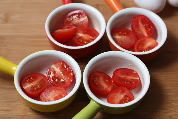В каждую формочку положите половинки помидоров черри, заполняя формы наполовину, и немного посолите. Количество помидоров в порции будет зависеть от размера формочек.