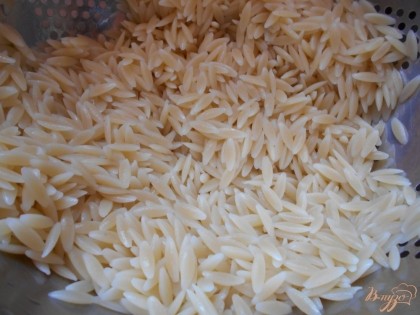 Тем временем отварим рис согласно инструкции на упаковке. Сольем воду и отбросим рис на дуршлаг.