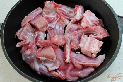Мясо кролика промываем в холодной воде и разрезаем на куски. На горячую сковородку наливаем немного подсолнечного масла и выкладываем кролика.