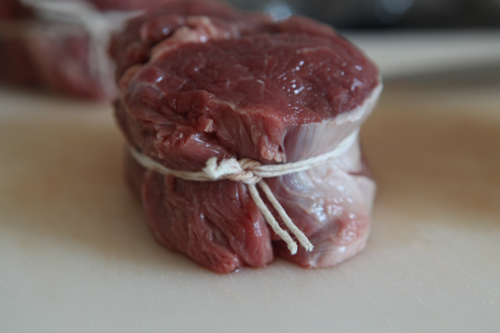 Режем мясо на стейки, я режу толщиной 4 см. Мясо нужно обвязать веревкой,  чтобы во время жарки оно не потеряло формы.
