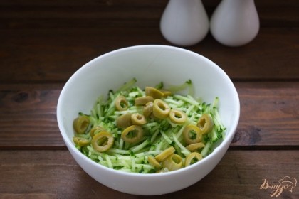 Зеленый оливки нарезать кружочками и добавить в салатник.