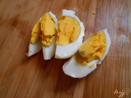 Отварное куриное яйцо разрезаем на четвертинки.